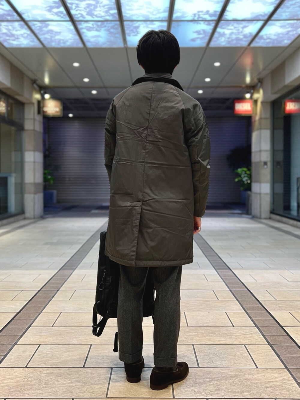 グレー系のダウンジャケット/コート、ブルー系のシャツ/ブラウス、ホワイト系のニット/セーターを着用したメンズの冬コーディネートの5枚目の写真