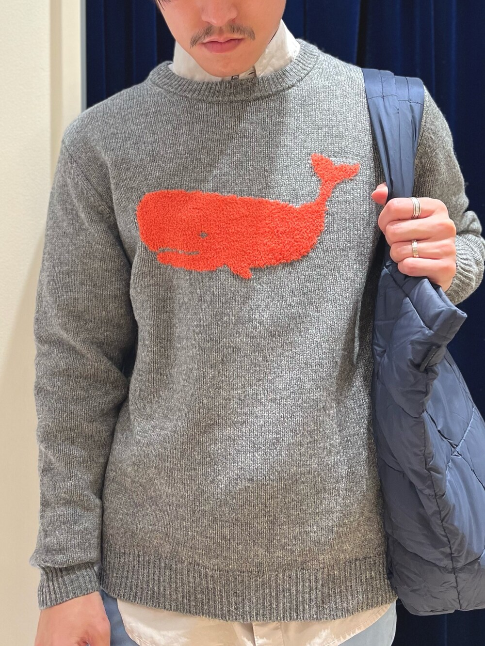 グレー系のニット/セーター、ベージュ系のシャツ/ブラウス、ブルー系のチノパンツを着用したメンズの冬コーディネートの6枚目の写真
