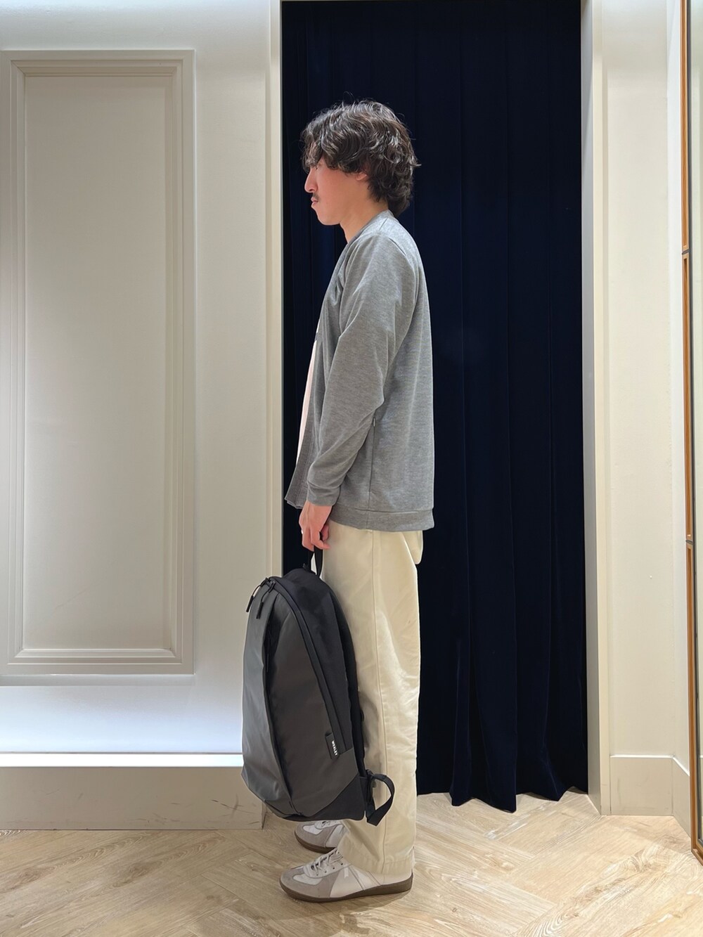 グレー系のカーディガン/ボレロ、ピンク系のTシャツ/カットソー、ブラック系のバックパック/リュックを着用したメンズの春コーディネートの5枚目の写真
