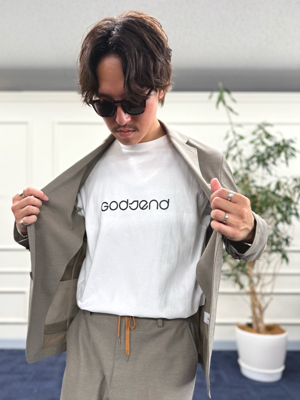 ベージュ系のテーラードジャケット、ベージュ系のその他パンツ、ホワイト系のTシャツ/カットソーを着用したメンズの夏コーディネートの7枚目の写真