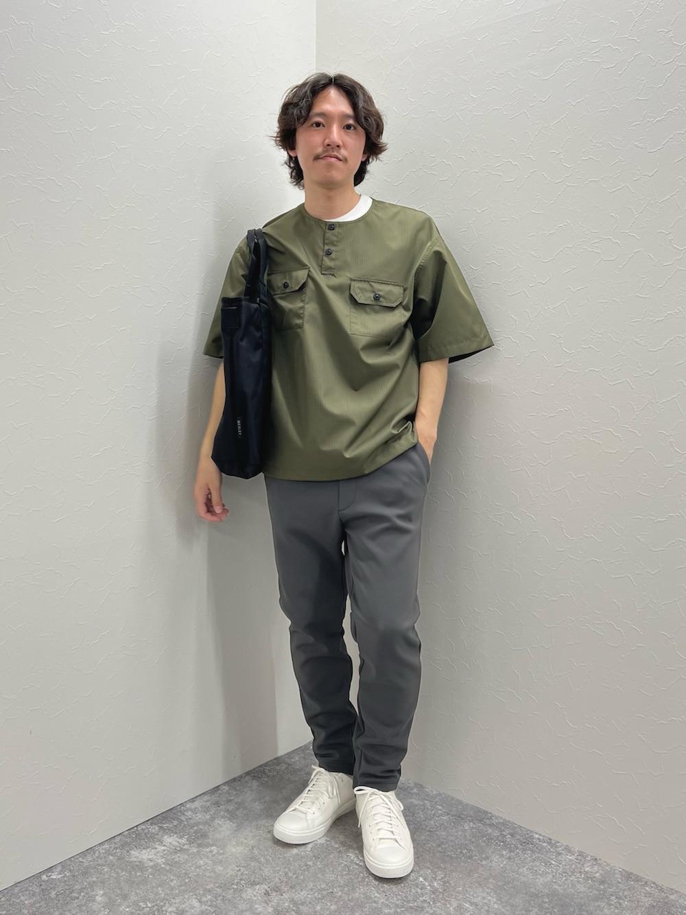 グリーン系のTシャツ/カットソー、ブラック系のトートバッグ、グレー系のその他パンツを着用したメンズの春コーディネートの3枚目の写真