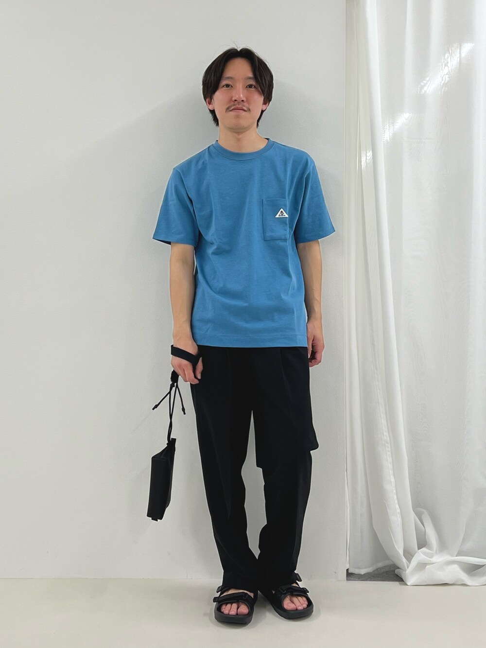 ブルー系のTシャツ/カットソー、ブラック系のその他パンツ、ブラック系のサンダルを着用したメンズの春コーディネートの3枚目の写真