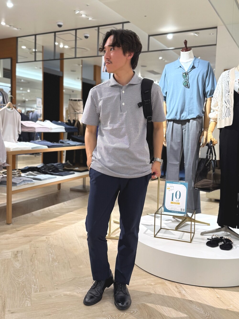 ブルー系のポロシャツ、ブルー系のその他パンツ、ブラック系のバックパック/リュックを着用したメンズの夏コーディネートの4枚目の写真