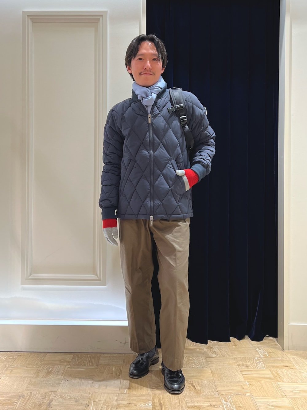 ブルー系のダウンジャケット/コート、ブラック系のバックパック/リュック、ブルー系のマフラーを着用したメンズの冬コーディネートの8枚目の写真