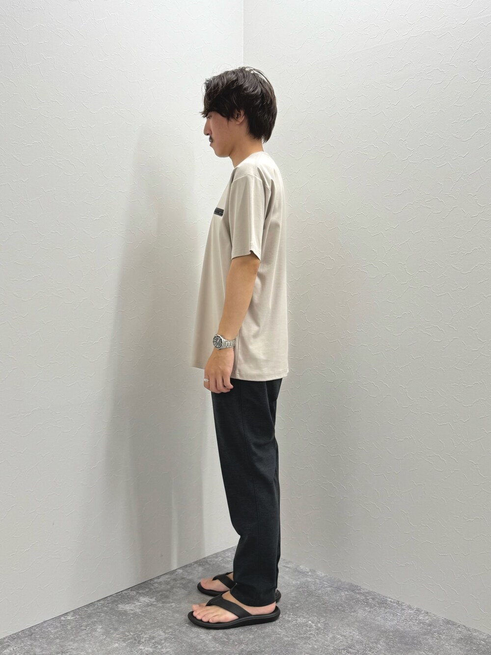 ベージュ系のTシャツ/カットソー、グレー系のその他パンツ、ブラック系のサンダルを着用したメンズの夏コーディネートの4枚目の写真