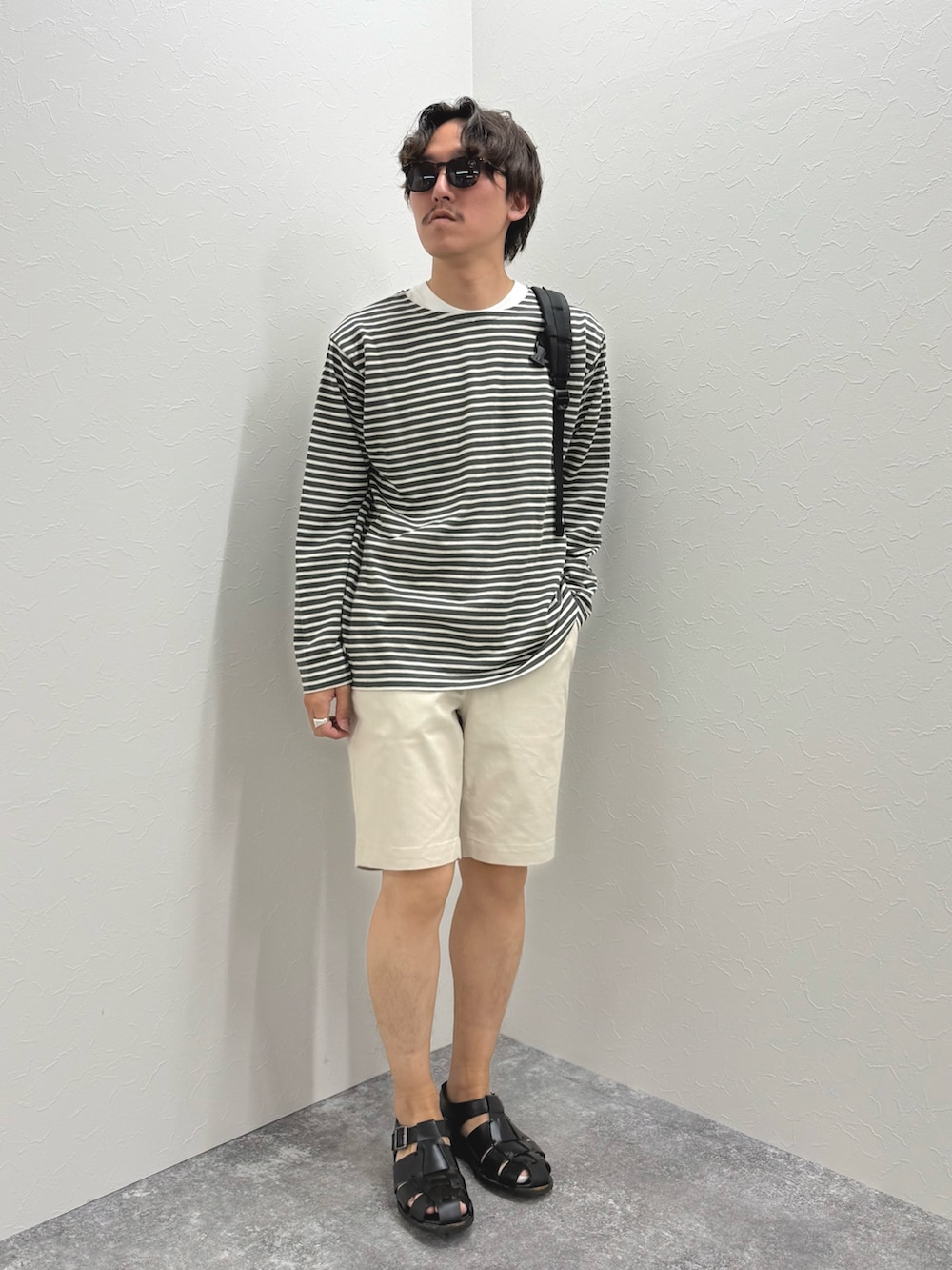 グレー系のTシャツ/カットソー、ホワイト系のその他パンツ、ブラック系のバックパック/リュックを着用したメンズの春コーディネートの5枚目の写真