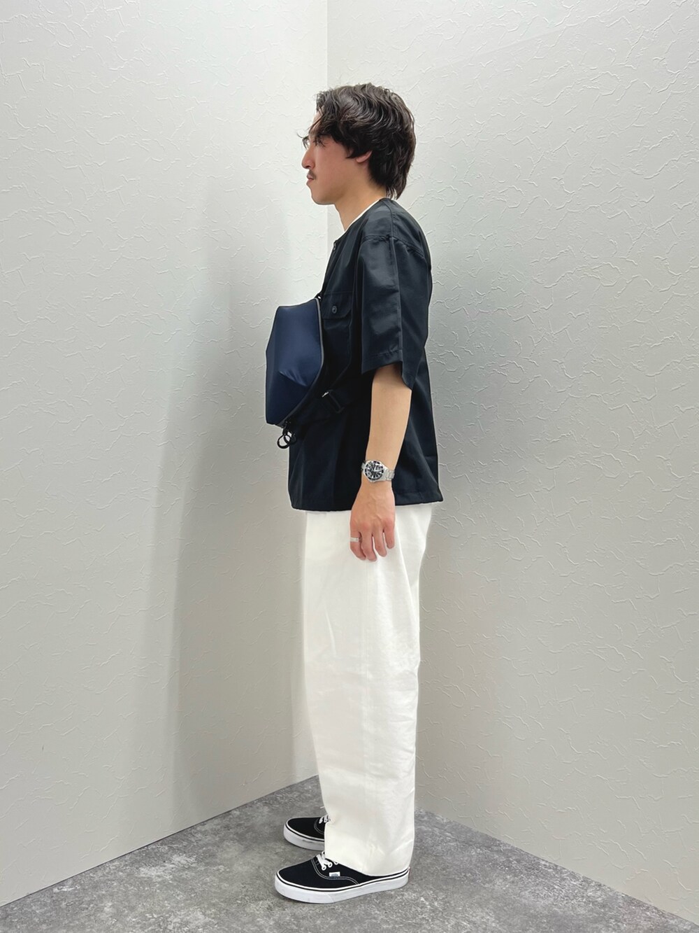 ブラック系のTシャツ/カットソー、ブルー系のショルダーバッグ、ホワイト系のデニムパンツを着用したメンズの春コーディネートの5枚目の写真
