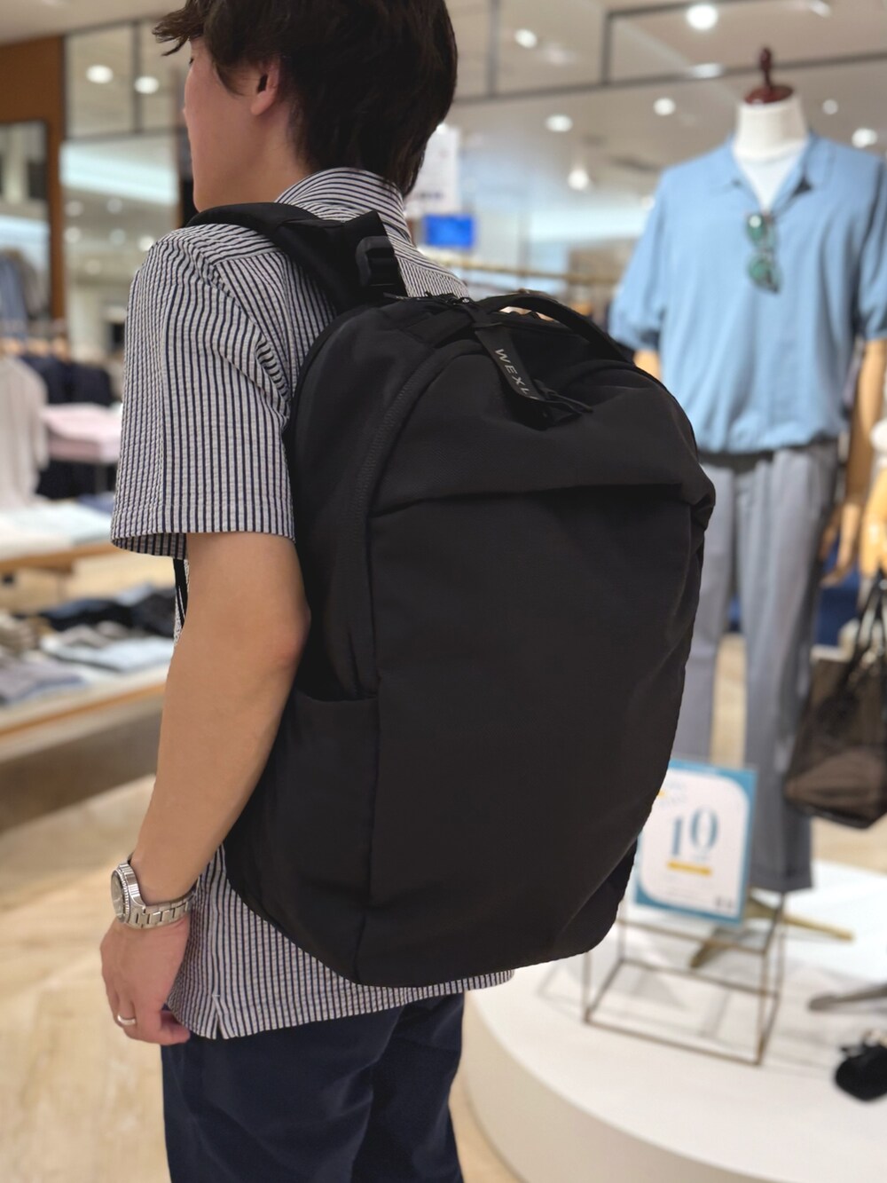 ブルー系のポロシャツ、ブルー系のその他パンツ、ブラック系のバックパック/リュックを着用したメンズの夏コーディネートの8枚目の写真