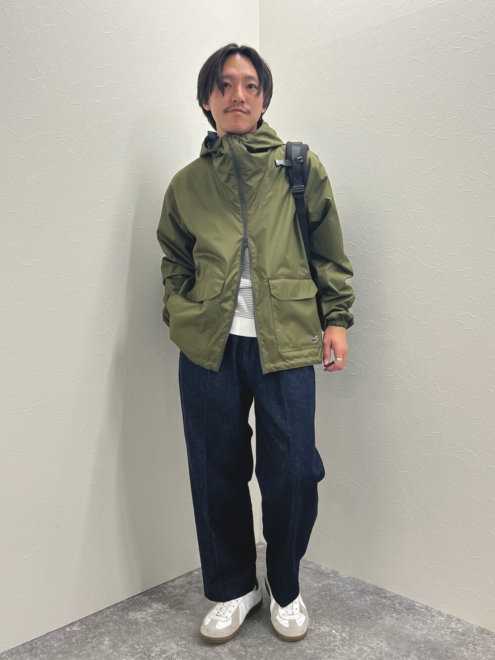 グリーン系のブルゾン、ホワイト系のTシャツ/カットソー、ブルー系のデニムパンツを着用したメンズの冬コーディネートの3枚目の写真