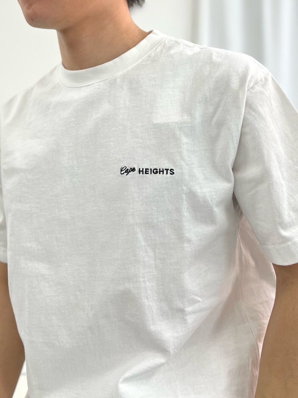 ホワイト系のTシャツ/カットソー、グレー系のトートバッグ、ブラック系のサンダルを着用したメンズの春コーディネートの6枚目の写真