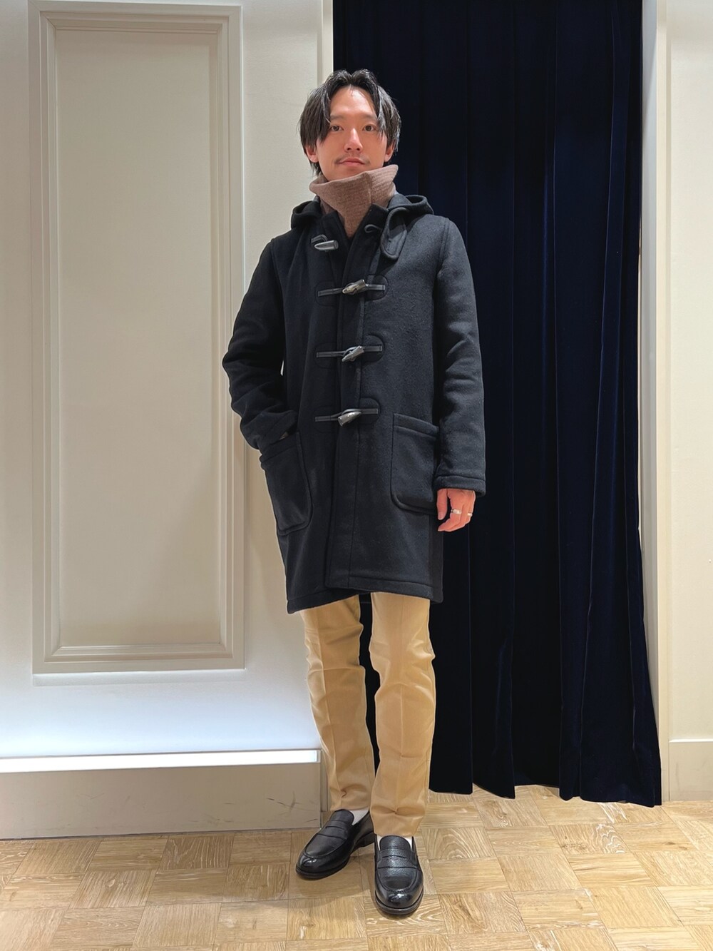 ブラック系のシャツ/ブラウス、ブラック系のダッフルコート、ベージュ系のその他パンツを着用したメンズの冬コーディネートの4枚目の写真