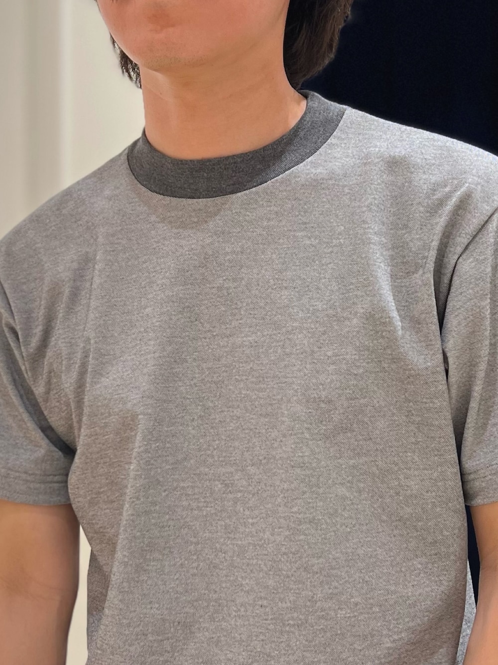 グレー系のTシャツ/カットソー、ブラック系のショルダーバッグ、ホワイト系のチノパンツを着用したメンズの春コーディネートの5枚目の写真