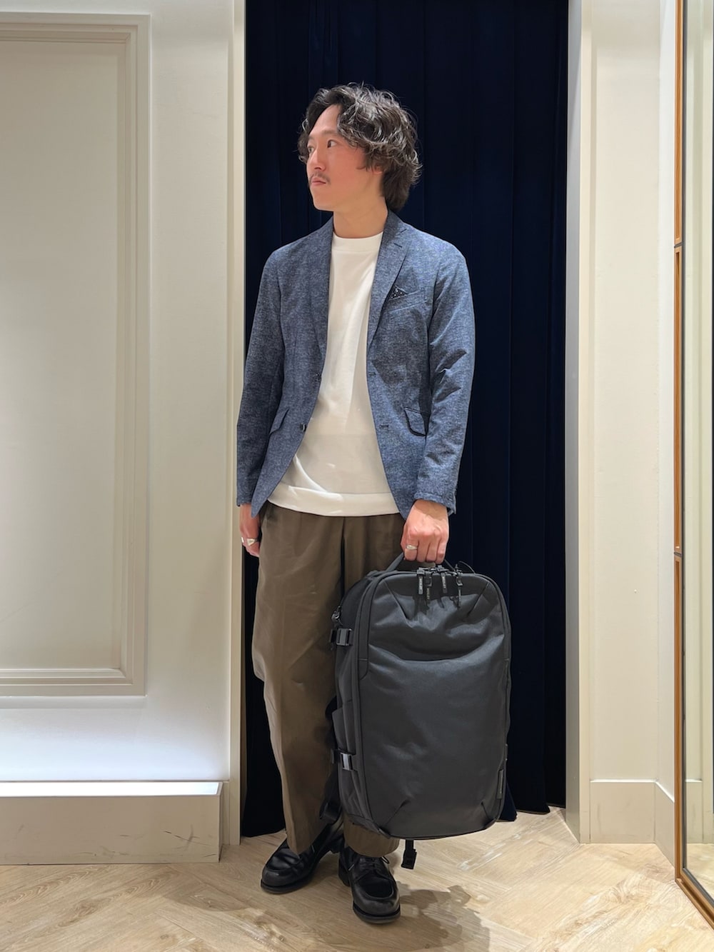 ホワイト系のTシャツ/カットソー、ブラック系のバックパック/リュック、ブラック系のその他シューズを着用したメンズの春コーディネートの2枚目の写真