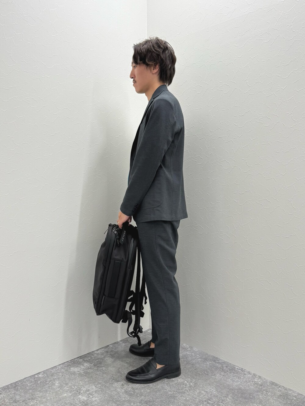 ブラック系のバックパック/リュック、ブラック系のローファー、ブルー系のTシャツ/カットソーを着用したメンズの夏コーディネートの5枚目の写真