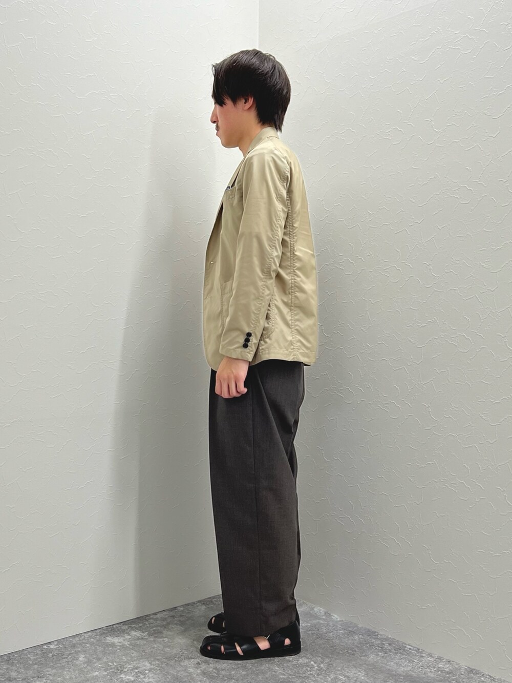 ベージュ系のテーラードジャケット、ホワイト系のTシャツ/カットソー、ブラック系のサンダルを着用したメンズの春コーディネートの4枚目の写真