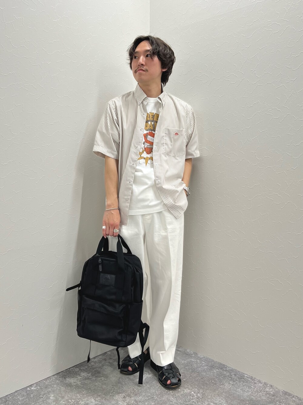 ホワイト系のTシャツ/カットソー、ブラック系のバックパック/リュック、ホワイト系のデニムパンツを着用したメンズの春コーディネートの5枚目の写真