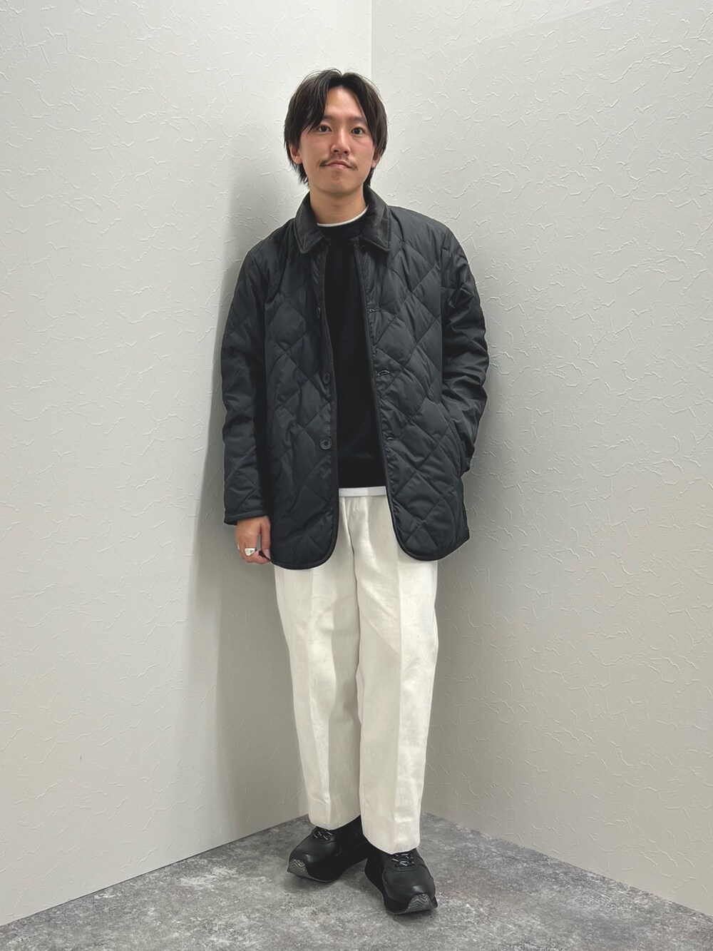 ブラック系のダウンジャケット/コート、ブラック系のTシャツ/カットソー、ブラック系のスニーカーを着用したメンズの秋コーディネートの3枚目の写真