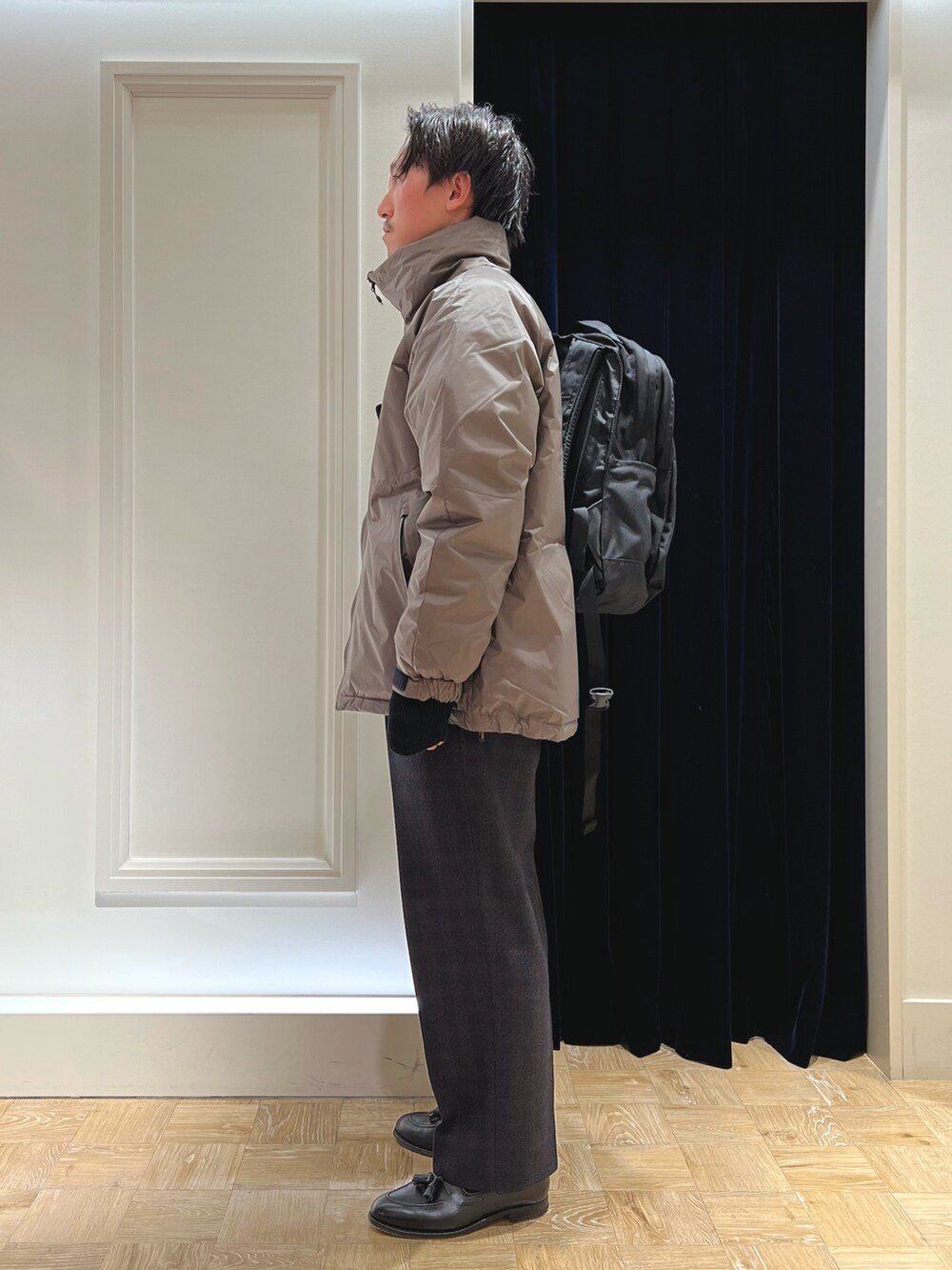 グレー系のダウンジャケット/コート、ブラック系のバックパック/リュックを着用したメンズの冬コーディネートの4枚目の写真
