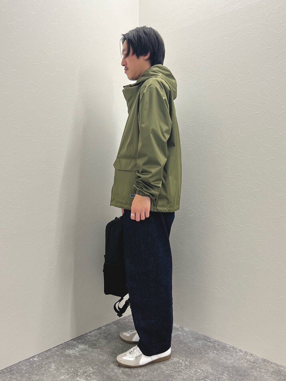 グリーン系のブルゾン、ホワイト系のTシャツ/カットソー、ブルー系のデニムパンツを着用したメンズの冬コーディネートの6枚目の写真