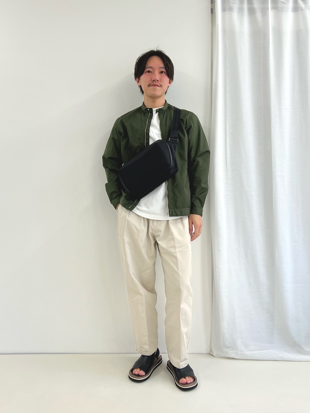 ホワイト系のTシャツ/カットソー、ブラック系のショルダーバッグ、ブラック系のサンダルを着用したメンズの春コーディネートの3枚目の写真