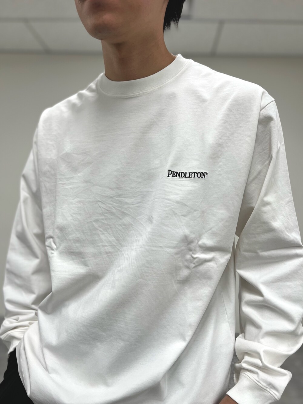 ホワイト系のTシャツ/カットソー、ブラック系のスニーカーを着用したメンズの秋コーディネートの6枚目の写真