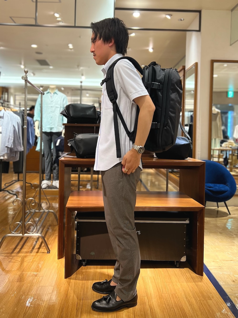 ホワイト系のシャツ/ブラウス、ブラック系のバックパック/リュック、ブルー系のその他パンツを着用したメンズの夏コーディネートの7枚目の写真