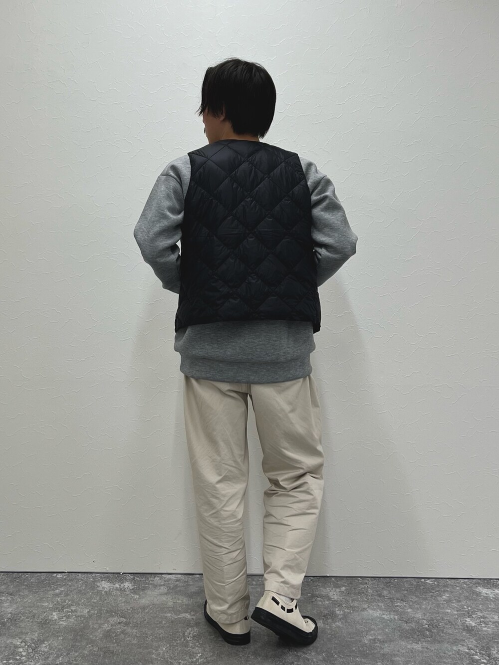 ブラック系のダウンベスト、グレー系のスウェットを着用したメンズの秋コーディネートの6枚目の写真