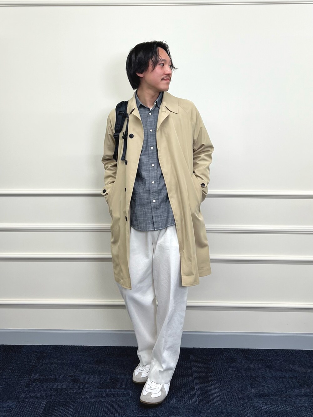 ベージュ系のステンカラーコート、ブラック系のシャツ/ブラウス、ホワイト系のデニムパンツを着用したメンズの冬コーディネートの4枚目の写真