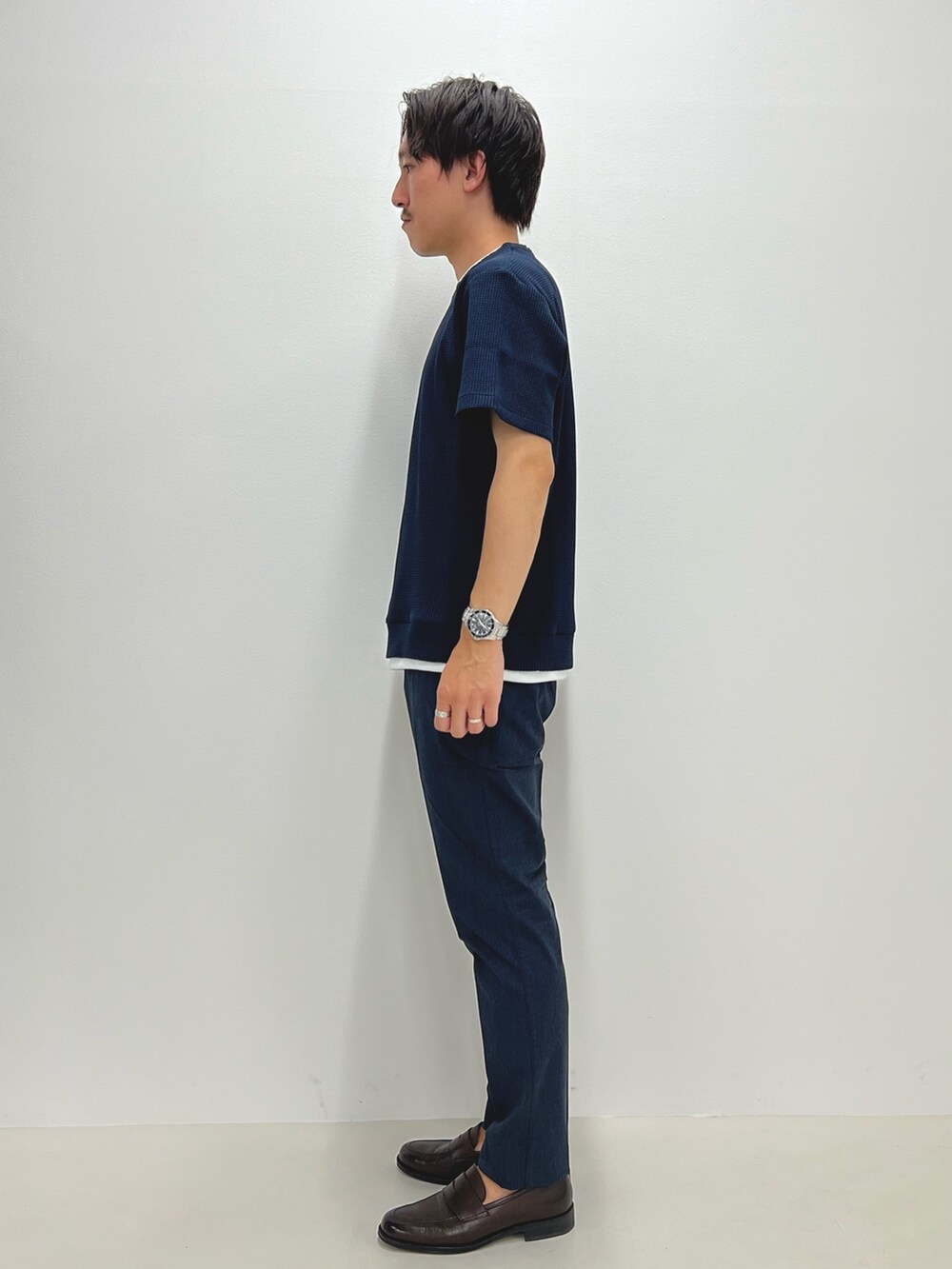 ブルー系のTシャツ/カットソー、ブルー系のチノパンツ、ブラウン系のローファーを着用したメンズの夏コーディネートの5枚目の写真