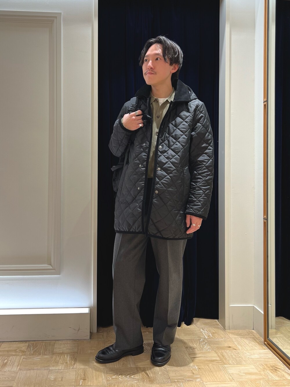 ブラック系のステンカラーコート、ブラック系のローファー、ブラック系のバックパック/リュックを着用したメンズの冬コーディネートの2枚目の写真