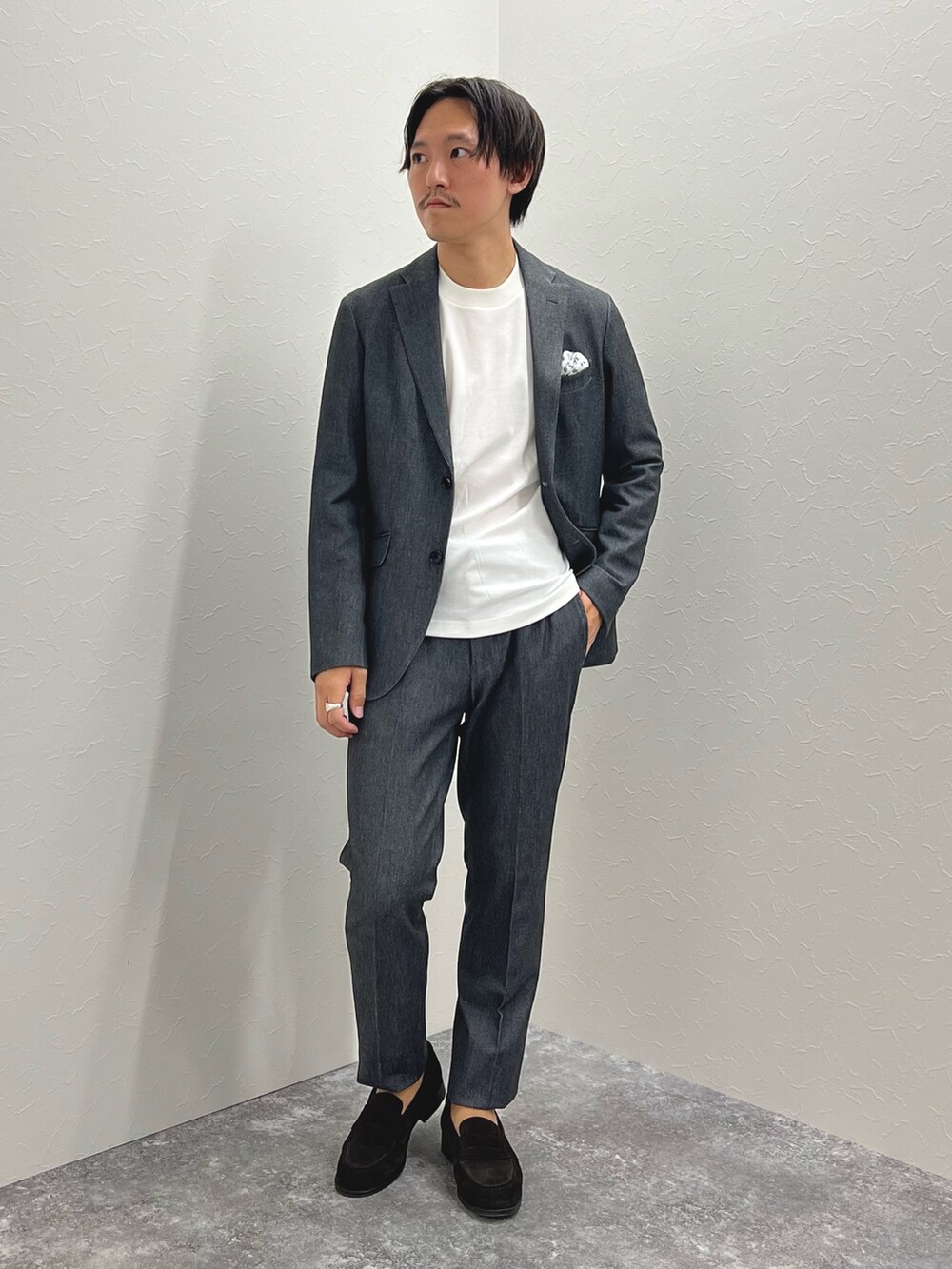 グレー系のテーラードジャケット、ホワイト系のTシャツ/カットソー、グレー系のその他パンツを着用したメンズの秋コーディネートの2枚目の写真