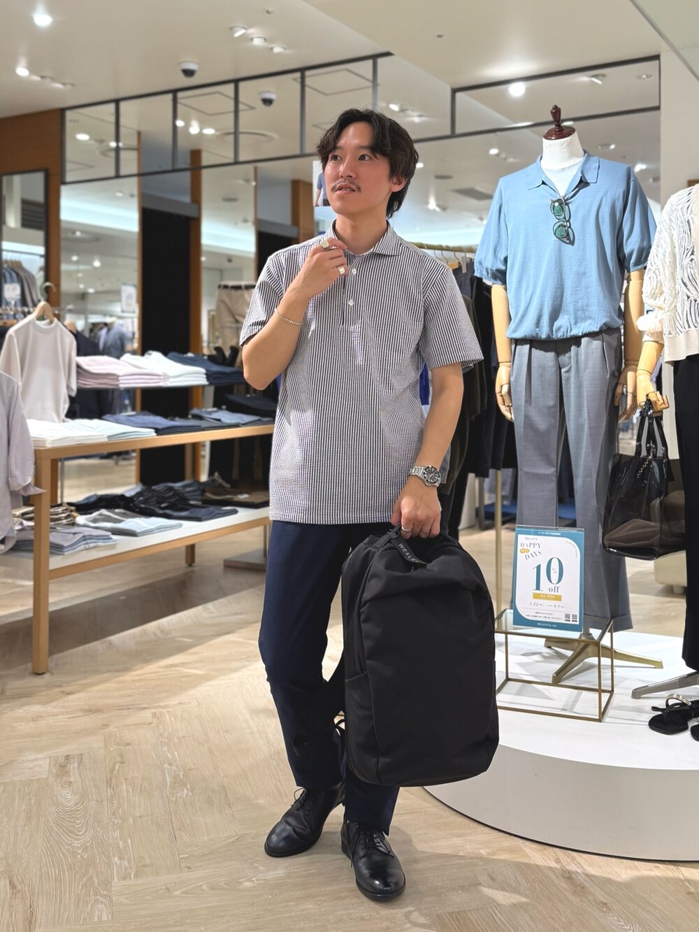 ブルー系のポロシャツ、ブルー系のその他パンツ、ブラック系のバックパック/リュックを着用したメンズの夏コーディネートの3枚目の写真