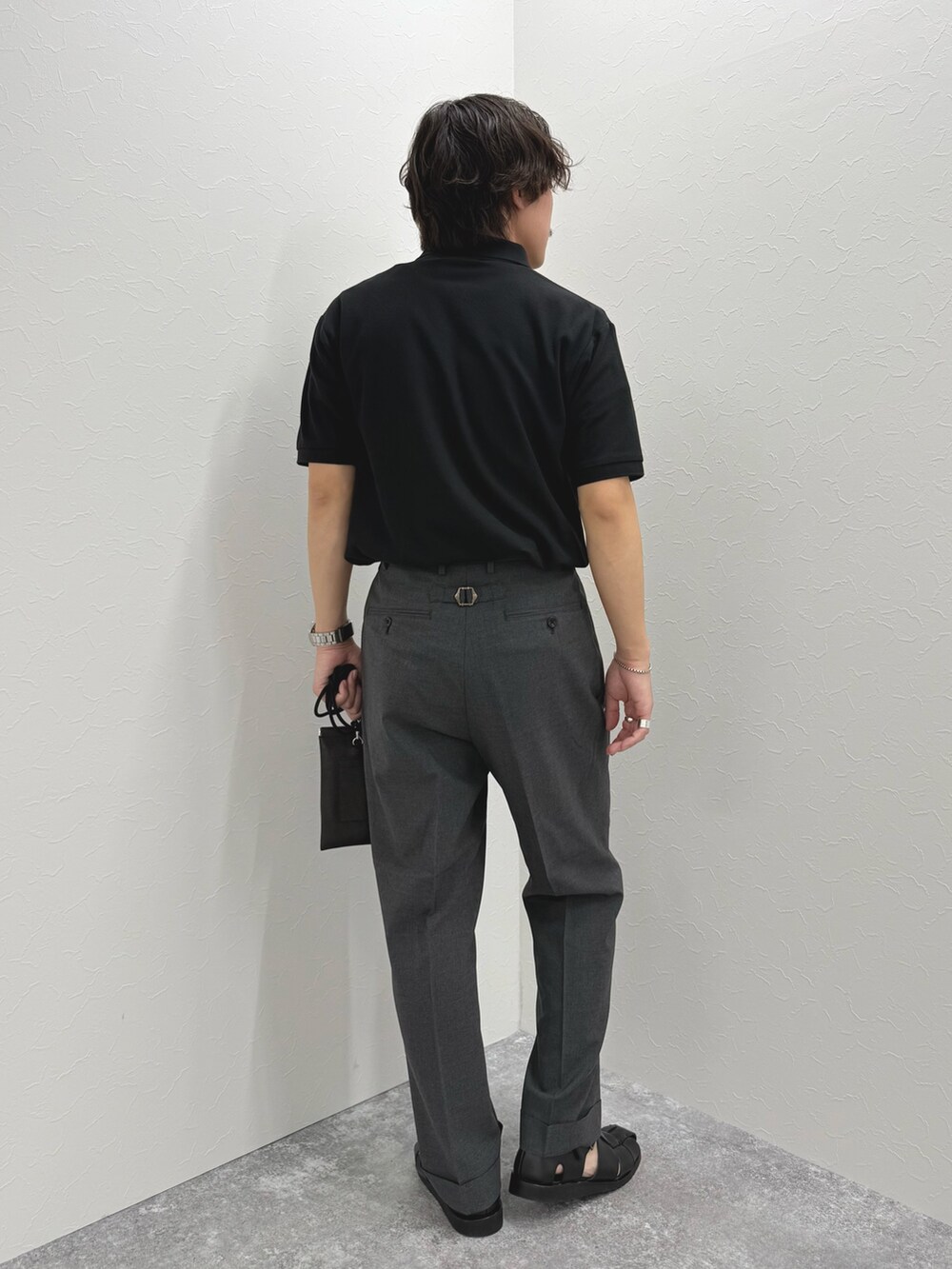 ブラック系のポロシャツ、ブラック系のショルダーバッグ、ブラック系のサンダルを着用したメンズの春コーディネートの6枚目の写真