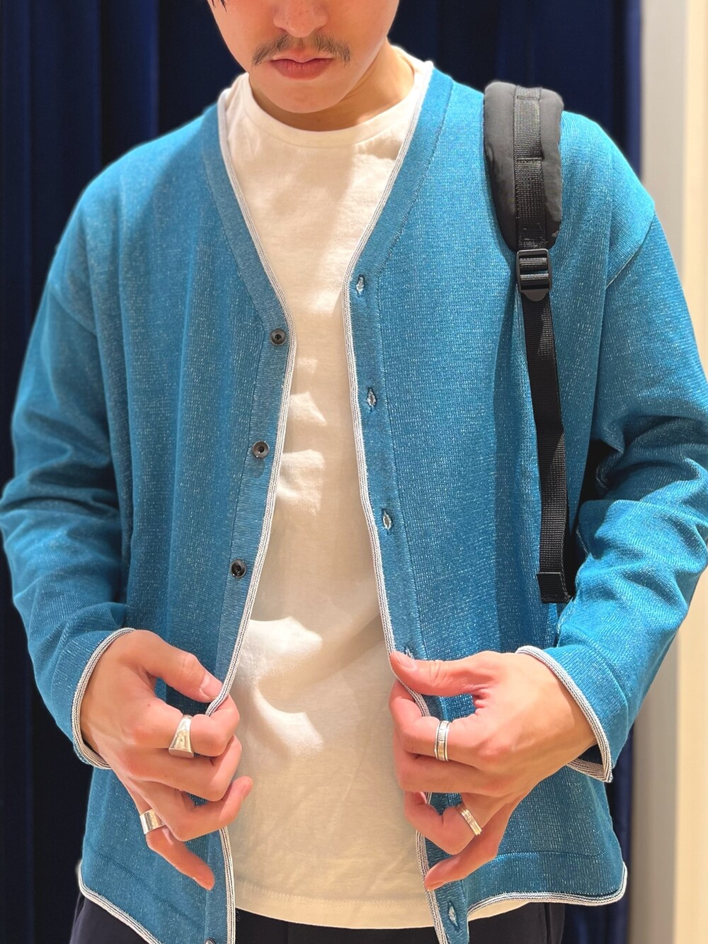 グリーン系のカーディガン/ボレロ、ブラック系のバックパック/リュックを着用したメンズの冬コーディネートの6枚目の写真