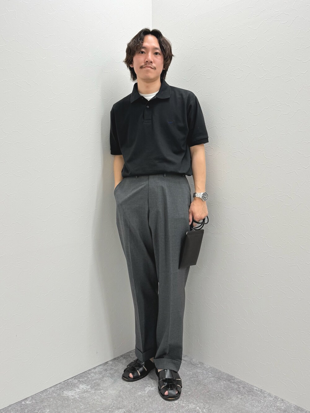 ブラック系のポロシャツ、ブラック系のショルダーバッグ、ブラック系のサンダルを着用したメンズの春コーディネートの4枚目の写真