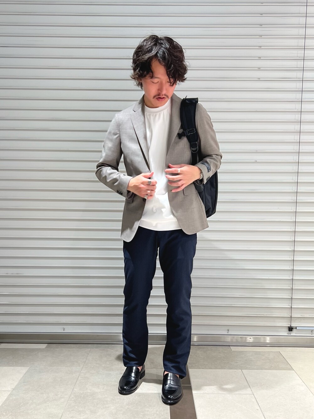 グレー系のテーラードジャケット、ホワイト系のTシャツ/カットソー、ブルー系のその他パンツを着用したメンズの春コーディネートの4枚目の写真