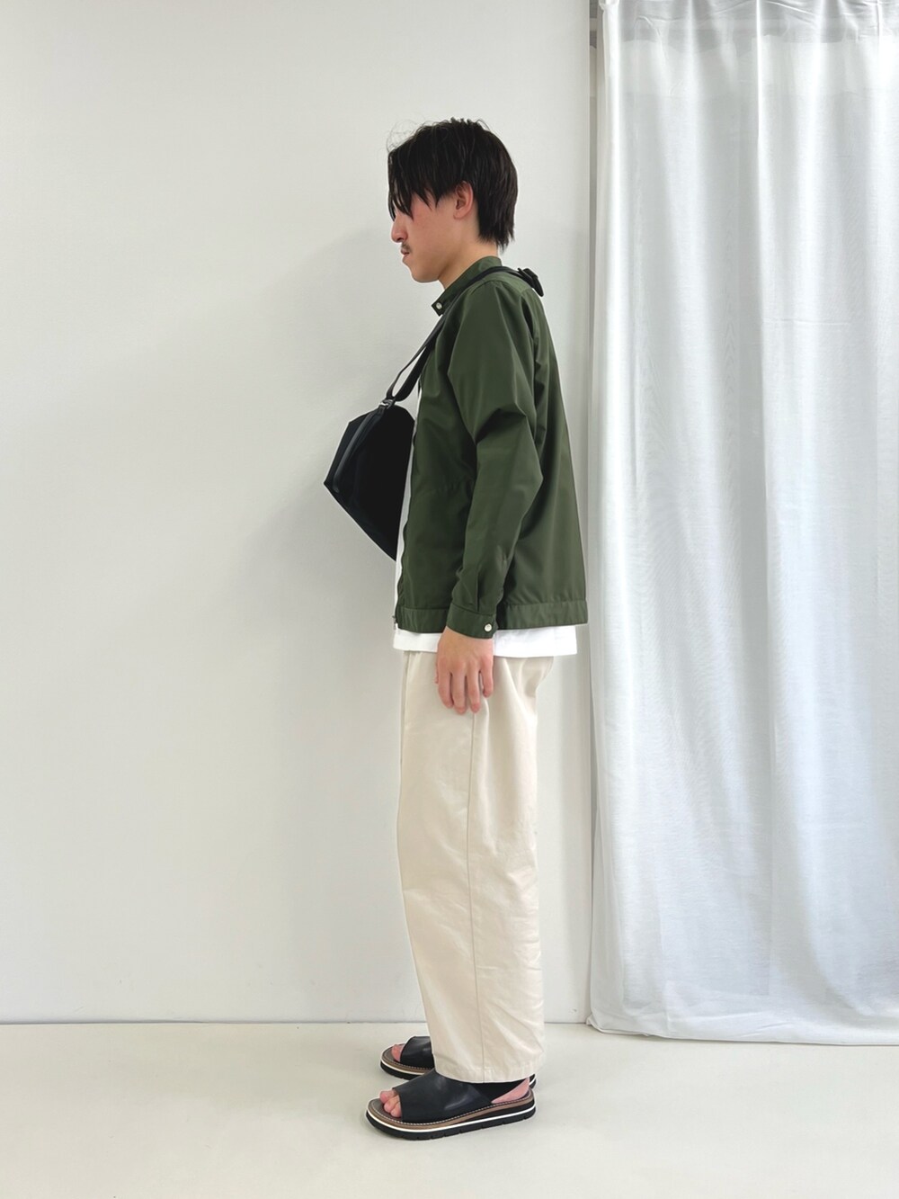 ホワイト系のTシャツ/カットソー、ブラック系のショルダーバッグ、ブラック系のサンダルを着用したメンズの春コーディネートの4枚目の写真