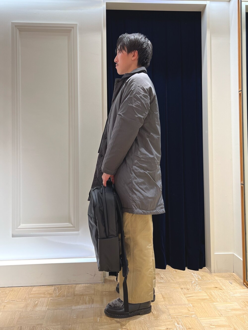 グレー系のダウンジャケット/コート、ブラック系のシャツ/ブラウス、レッド系のニット/セーターを着用したメンズの冬コーディネートの3枚目の写真