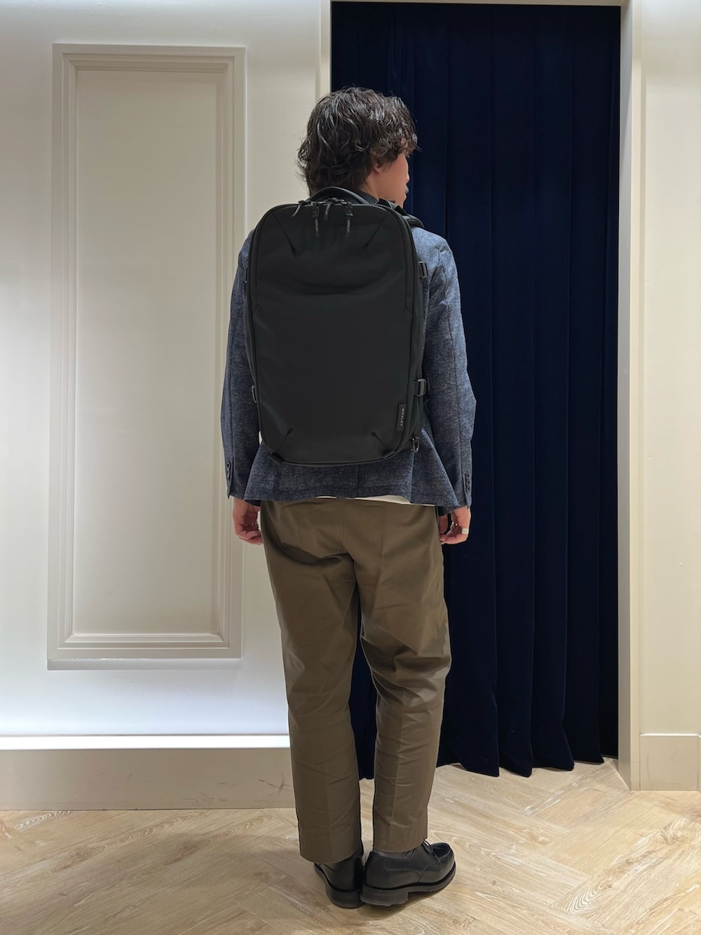 ホワイト系のTシャツ/カットソー、ブラック系のバックパック/リュック、ブラック系のその他シューズを着用したメンズの春コーディネートの9枚目の写真