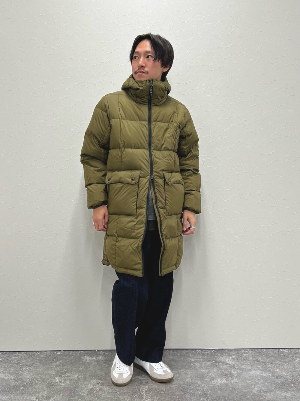 グリーン系のダウンジャケット/コート、グレー系のニット/セーター、グリーン系のシャツ/ブラウスを着用したメンズの冬コーディネートの4枚目の写真