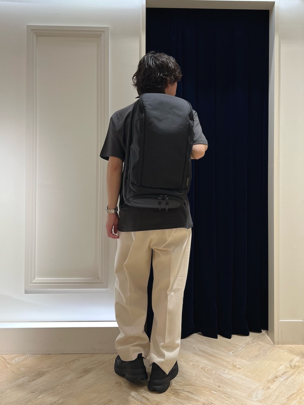 ブラック系のTシャツ/カットソー、ブラック系のバックパック/リュック、ブラック系のスニーカーを着用したメンズの春コーディネートの9枚目の写真