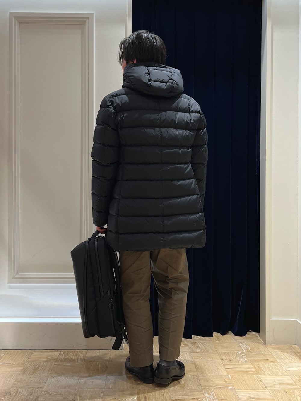 グレー系のテーラードジャケット、ブラック系のバックパック/リュック、ブラック系のダウンジャケット/コートを着用したメンズの冬コーディネートの5枚目の写真