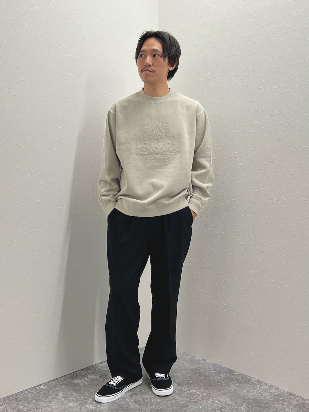 ベージュ系のスウェット、ブラック系のスニーカーを着用したメンズの秋コーディネートの3枚目の写真