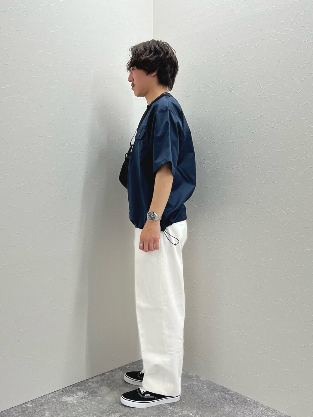 ブルー系のTシャツ/カットソー、ブラック系のショルダーバッグ、ホワイト系のデニムパンツを着用したメンズの春コーディネートの3枚目の写真