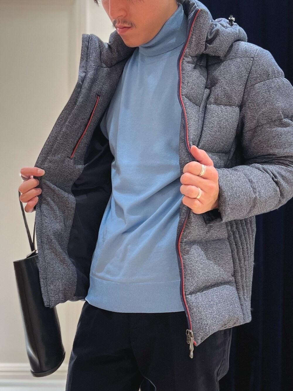 ブルー系のダウンジャケット/コート、ブルー系のニット/セーター、ブルー系のチノパンツを着用したメンズの秋コーディネートの6枚目の写真