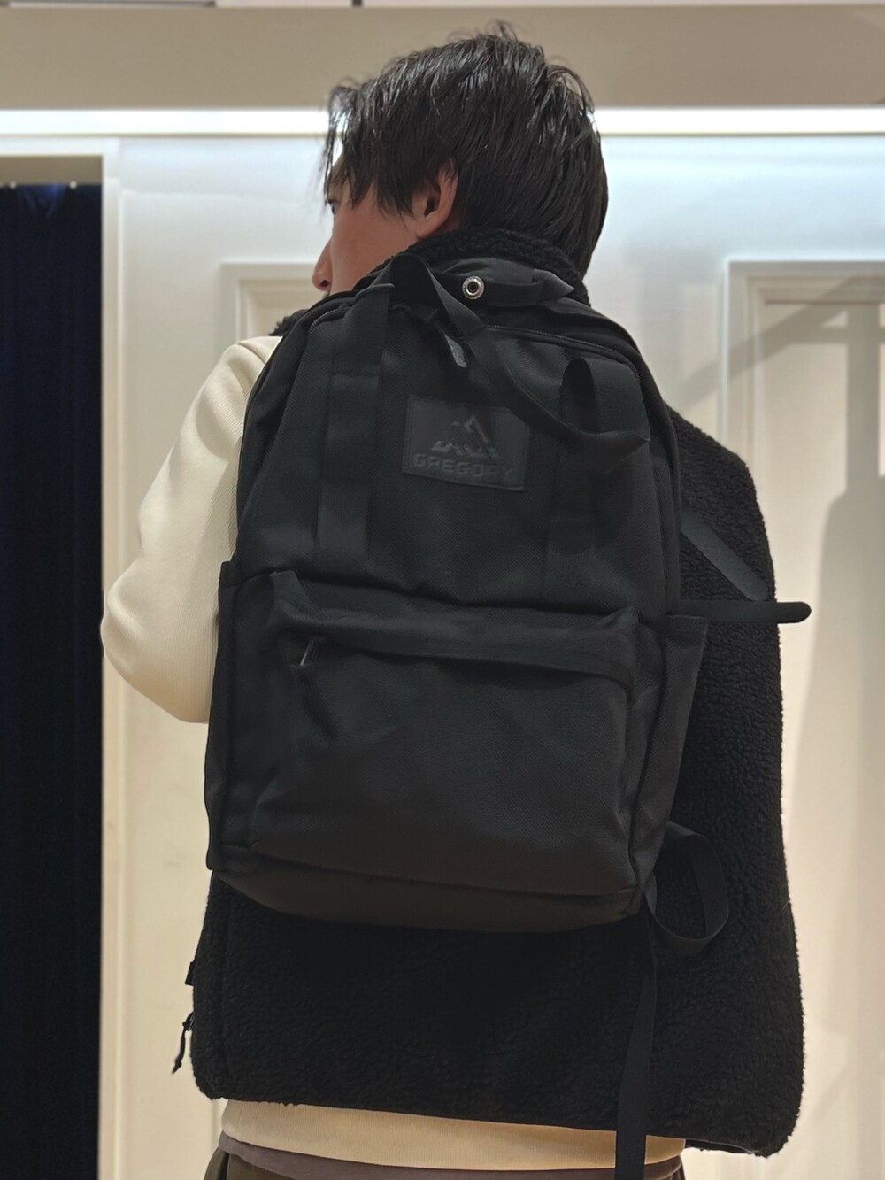 ブラック系のダウンベスト、ホワイト系のTシャツ/カットソー、ブラック系のバックパック/リュックを着用したメンズの秋コーディネートの6枚目の写真