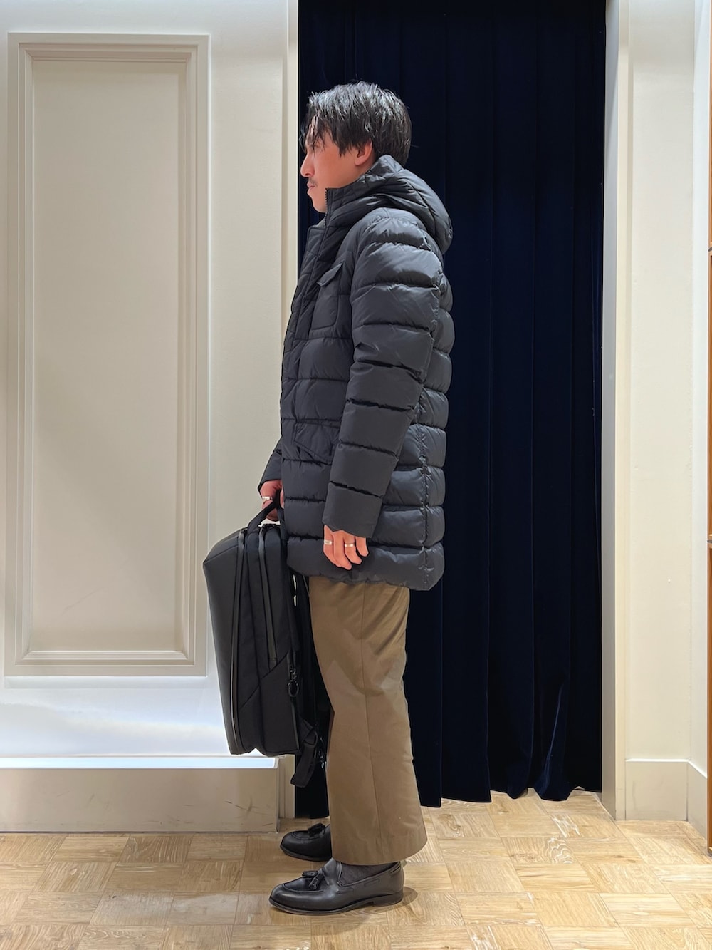 グレー系のテーラードジャケット、ブラック系のバックパック/リュック、ブラック系のダウンジャケット/コートを着用したメンズの冬コーディネートの4枚目の写真