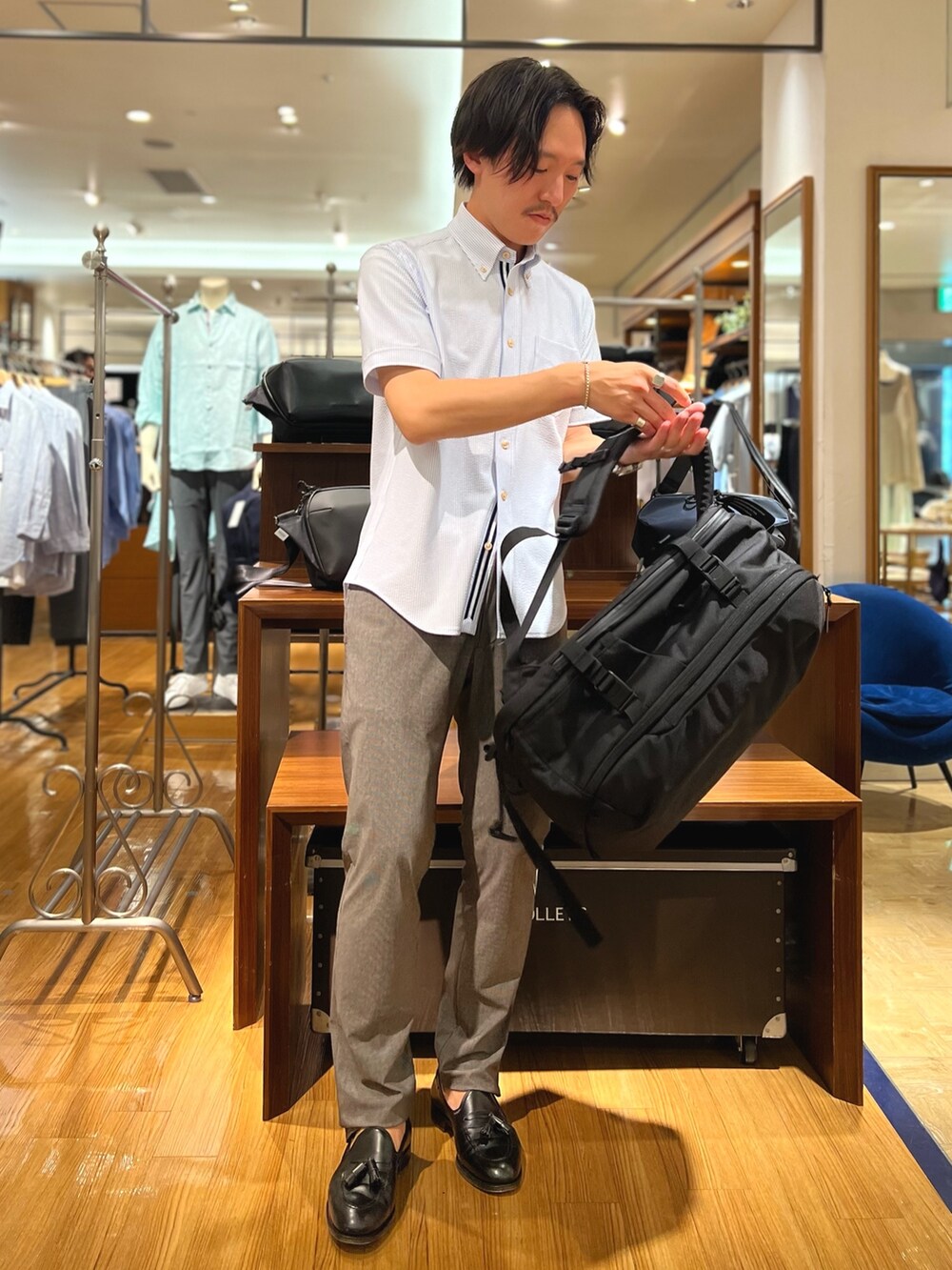 ホワイト系のシャツ/ブラウス、ブラック系のバックパック/リュック、ブルー系のその他パンツを着用したメンズの夏コーディネートの3枚目の写真