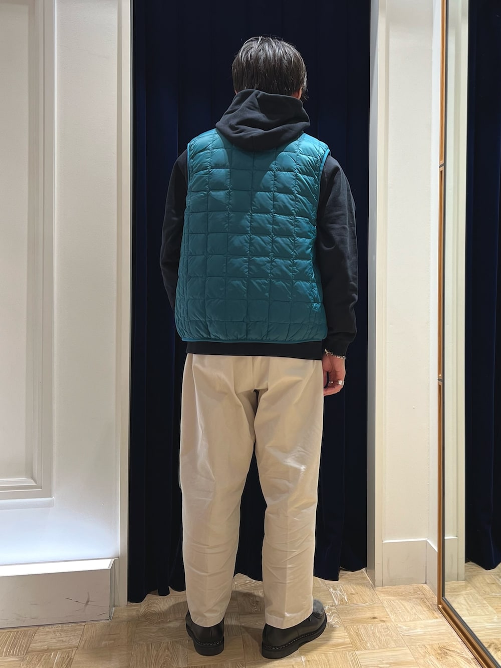 ブラック系のパーカー、グリーン系のダウンベスト、グリーン系のショルダーバッグを着用したメンズの秋コーディネートの4枚目の写真