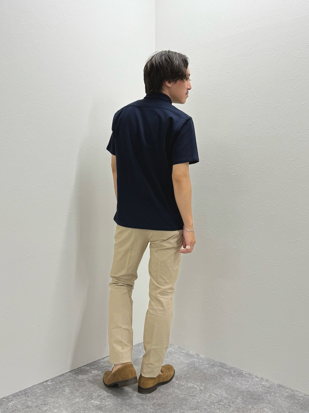 ブルー系のポロシャツ、ベージュ系のチノパンツ、イエロー系のローファーを着用したメンズの夏コーディネートの4枚目の写真